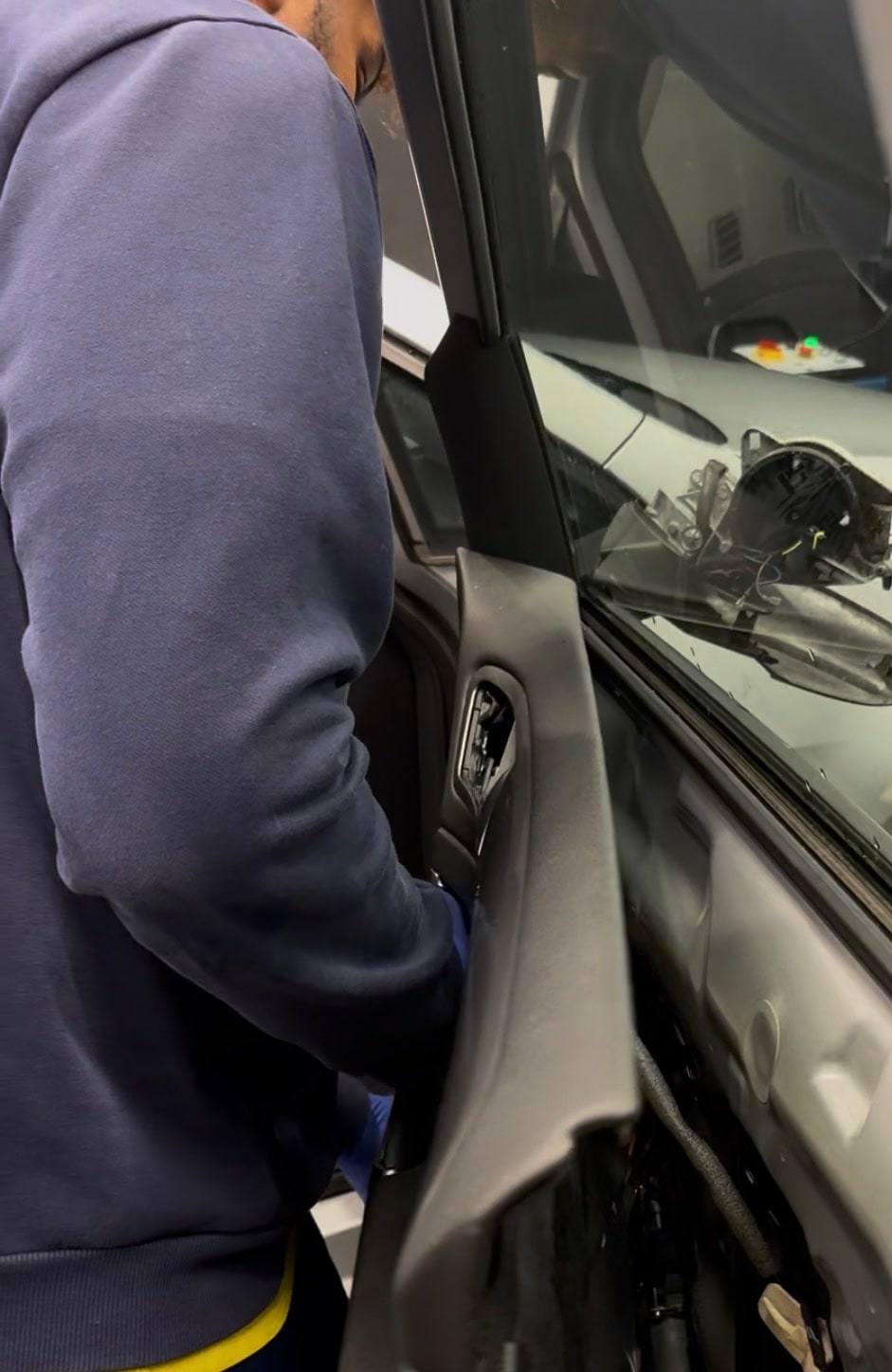 An Al Midra team member working on the inside of a car door